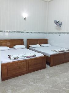 duas camas sentadas uma ao lado da outra num quarto em Nhà Nghỉ Tiến Phúc 1 em Long Hai