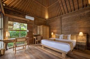 乌布RUMAH KAYU RESORT的带床和书桌的卧室