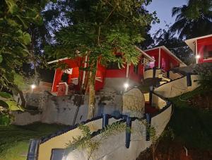 a house with a tree in front of it at VIP GARDEN RESORT in Varkala +24 photos