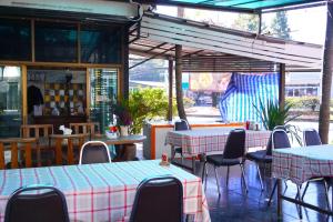 pusta restauracja ze stołami, krzesłami i stolarką w obiekcie Tamnak Lanta @Chiang Mai w mieście Chiang Mai