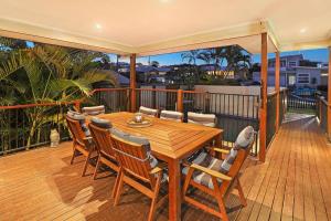 a wooden table and chairs on a deck at Luxury Holiday Home in Alex - Heated Pool - Pets Allowed in Alexandra Headland