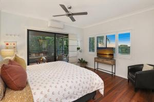 a bedroom with a bed and a flat screen tv at Luxury Holiday Home in Alex - Heated Pool - Pets Allowed in Alexandra Headland