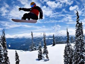 un hombre volando por el aire en una tabla de snowboard en Yunohara, en Mogami