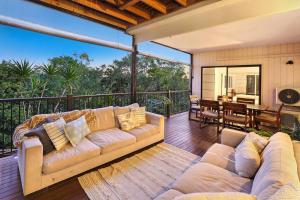 a living room with a couch on a deck at Luxury Holiday Home in Alex - Heated Pool - Pets Allowed in Alexandra Headland