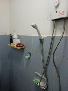 - une pomme de douche dans une salle de bains carrelée de bleu dans l'établissement ban noo, à Ban Ko