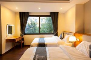 um quarto de hotel com duas camas e uma janela em Laika Hotel Sapa em Sapa