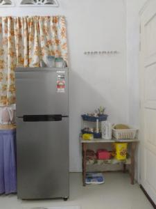 eine Küche mit einem Kühlschrank und einem Tisch in der Unterkunft Layya Homestay in Pasir Mas