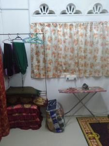a room with a curtain and a shelf and a window at Layya Homestay in Pasir Mas