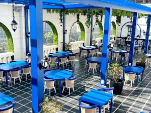 Planet Hollywood Thane في ثين: غرفة بها طاولات زرقاء وكراسي على الفناء