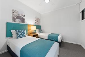 Dos camas en una habitación de hotel con azul y blanco en Club Wyndham Flynns Beach, Trademark Collection by Wyndham en Port Macquarie