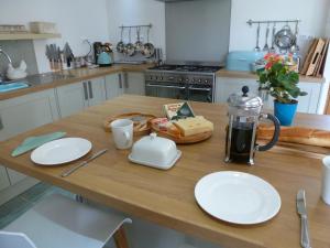 uma cozinha com uma mesa de madeira com placas em Maison Galloise em Auzances