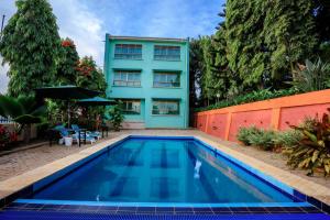 a swimming pool in front of a house at Victoria View Boutique Hotels Kigo in Entebbe