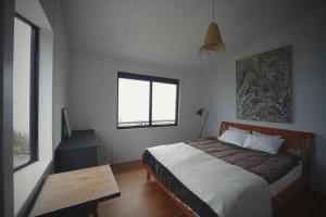 1 dormitorio con cama, mesa y ventana en STRADDIE HOUSE tateyama, en Tateyama