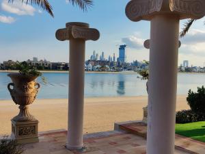 two columns with a view of a beach and a city at Palm's Largest Beachfront Estate in Dubai