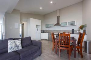sala de estar con sofá, mesa y sillas en Waverley apartment B-one bedroom wifi available en Perth