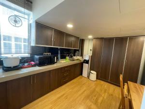 a kitchen with wooden cabinets and a wooden floor at Illusyin Retreat in Shah Alam