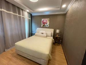 um quarto com uma cama branca num quarto em Illusyin Retreat em Shah Alam