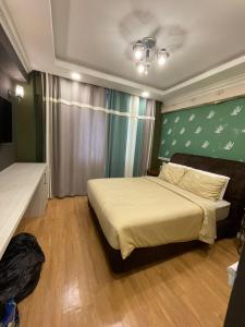 um quarto com uma cama e uma parede verde em Illusyin Retreat em Shah Alam