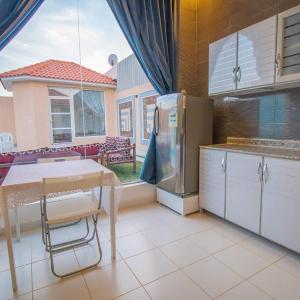 a kitchen with a table and a refrigerator at شاليهات نبراس in Riyadh
