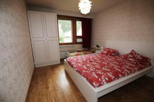 sypialnia z łóżkiem z czerwoną pościelą i oknem w obiekcie Holiday Home - Detached house 108m2, 3 rooms, 1 living room, Sauna w mieście Joensuu