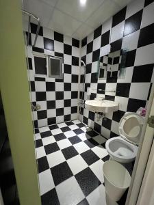 a bathroom with a black and white checkered floor at 5-1 Homestay in Kenting