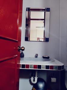 a bathroom with a sink and a mirror at Hostal Casa de Ana in Nazca