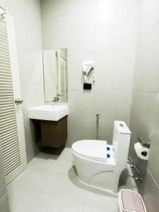 a white bathroom with a toilet and a sink at Port Station Koh Tao in Koh Tao