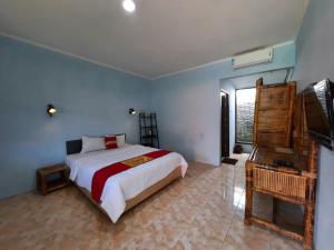 a bedroom with a bed and a television in it at HOTEL BESAR BULAN BARU - Senggigi in Senggigi