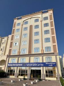 ein großes Gebäude mit einem Schild davor in der Unterkunft Weekdays Hotel in Muscat