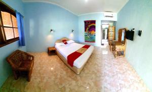 - une chambre avec un lit dans une pièce aux murs bleus dans l'établissement HOTEL BESAR BULAN BARU - Senggigi, à Senggigi