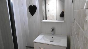 a bathroom with a sink and a heart on the wall at Appartement LE COURS in Barbentane