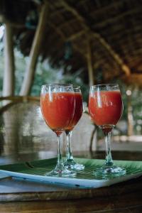 dos copas de vino sentadas en un plato en una mesa en Eco Bliss Cottages - Thanamalwila, 