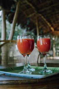 two wine glasses sitting on a plate on a table at Eco Bliss Cottages - Thanamalwila in Nikawewa +41 photos