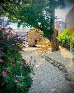 un jardín con un árbol y algunas flores y rocas en Beautiful country retreat for 6, with free parking, en Carlisle