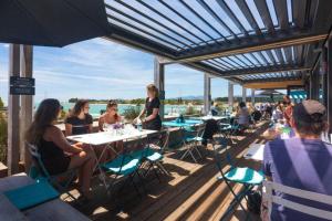 a group of people sitting at tables on a deck at Ruby Bay Loft Accommodation in Nelson