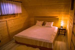1 dormitorio con 1 cama en una cabaña de madera en Domek Muflon w Górach Sowich, en Jugów