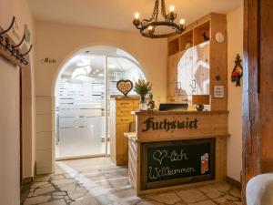 a kitchen with an arched entryway with a sign on the counter at Fuchswirt Kelchsau Landgasthof-Hotel in Hopfgarten im Brixental