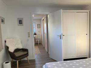 1 dormitorio con cama, silla y armario en Metter, en Bietigheim-Bissingen