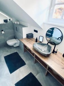 Chalet Badberg في باد جاستاين: حمام مع حوض ومرآة ومرحاض