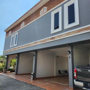 a house with a garage with a car parked in front at Loft House Resort Pattaya in Jomtien Beach