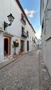 an empty alley with white buildings and a street at El amante Altea in Altea