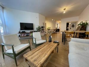 uma sala de estar com uma mesa de café em madeira e cadeiras em Amazing vacation flat em Netanya