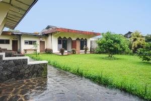 una casa con un arroyo delante de ella en OYO Life 92087 Griya Nurainy, en Pasuruan