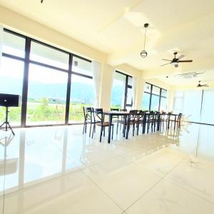 a dining room with a table and chairs and windows at Xian Jing B&B in Jiaoxi