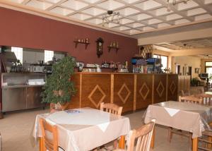 a dining room with two tables and a bar at Morfoula in Vatera