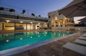 a large swimming pool in front of a building at מטע וכרם in Elqosh