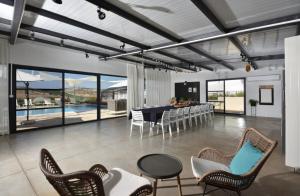 a living room with a table and chairs and a pool at מטע וכרם in Elqosh