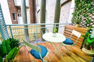 einen Tisch und Stühle auf einem Balkon mit Pflanzen in der Unterkunft CBD #UnitA Grennland6 1 bedroom apt Darling Harbour in Sydney