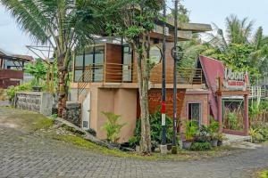 ein Gebäude mit Palmen davor in der Unterkunft OYO 92084 Candi Candi Ubud Syariah in Pandakan