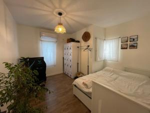 Un dormitorio con una cama y una planta. en Amazing vacation flat, en Netanya